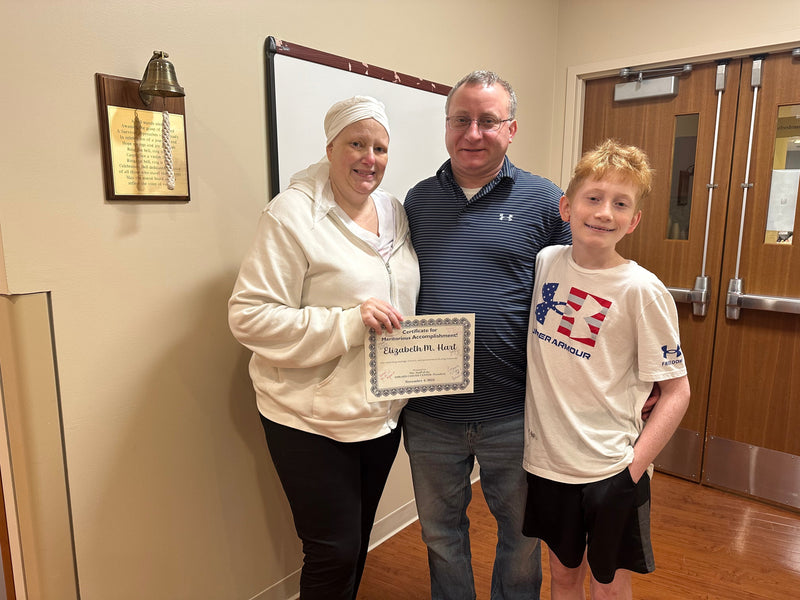 Me with my husband and son in front of the chemo bell.